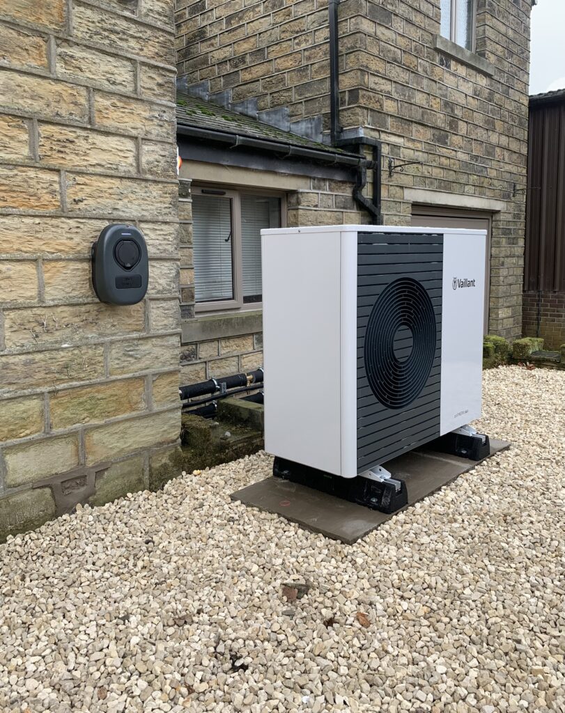 Air source heat pump with electric vehicle charger